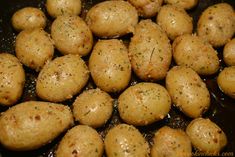 potatoes are being cooked in a pan with oil and seasoning on them for garnish