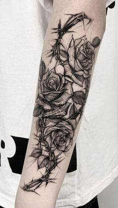 a black and white rose tattoo on the right arm, with an arrow in the middle