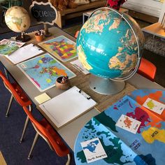 a table topped with lots of different types of globes and papers on top of it