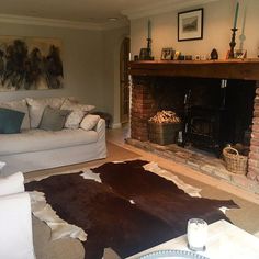 a living room filled with furniture and a fire place in front of a brick fireplace