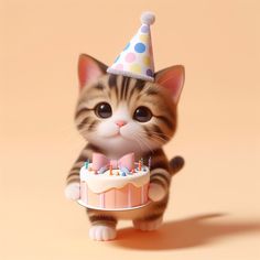 a small kitten is holding a birthday cake