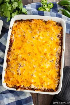 an enchilada casserole with cheese and meat in a white dish