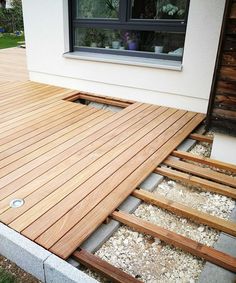 a wooden deck is being installed on the side of a house with wood slats