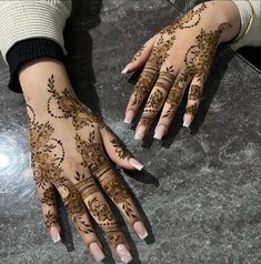 two hands with henna tattoos on them