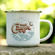 a white camper mug sitting on top of a wooden table