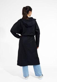 Stay dry and stylish in our women's long black raincoat with a hood. Constructed from a 100% polyester memory fabric, this compact coat is ideal for travel, as it retains it shape after being stuffed into your suitcase. Adjustable drawcords at waist and hood for customizable, feminine styling. Deep inseam side pockets for carrying personal items, impeccably finished with bias bound seaming throughout interior. Water resistant protection from the rain. Built-in travel pocket for packing convenien Black Weatherproof Raincoat For Work, Black Weatherproof Workwear Raincoat, Solid Color Raincoat With Adjustable Hood For Travel, Solid Raincoat With Adjustable Hood For Travel, Black Hooded Raincoat For Work, Travel Raincoat With Detachable Hood, Black Nylon Raincoat With Detachable Hood, Black Outerwear With Double-lined Hood For Travel, Black Travel Outerwear With Double-lined Hood