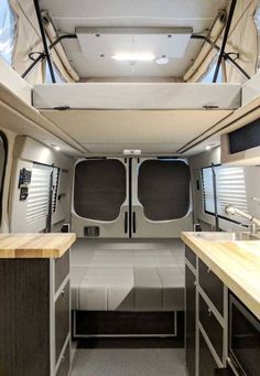 the interior of a camper van with wood counter tops