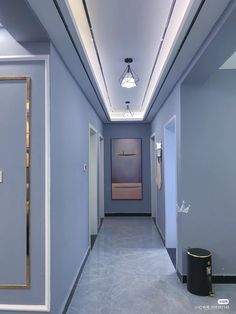 an empty hallway with blue walls and white trim on the ceiling is seen in this image