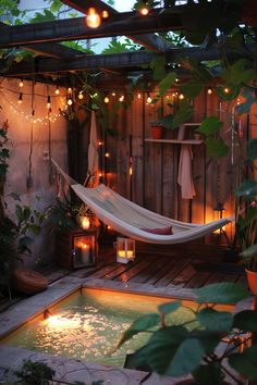 a hammock in the middle of a small pool with lights strung around it