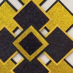 a black and yellow mosaic tile design with gold glitter squares in the center, on a white background