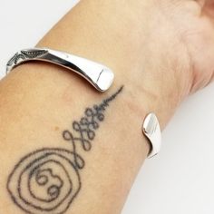 a close up of a person's arm with a tattoo design on the wrist