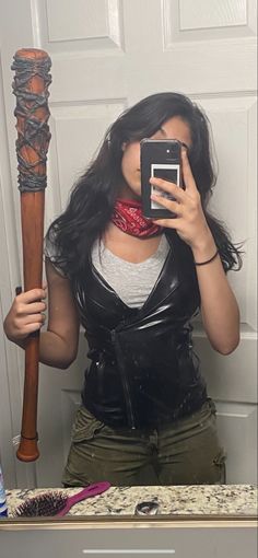 a woman taking a selfie in front of a mirror with a baseball bat on her shoulder