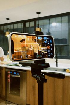 a man standing next to a kitchen counter with a cell phone on top of it