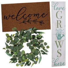 a welcome sign and door mat next to a wreath