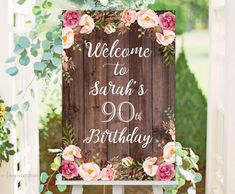 a wooden sign that says welcome to sarah's 90th birthday with flowers on it