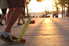 a person standing on top of a skateboard next to another persons legs and feet