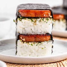 three pieces of sushi stacked on top of each other with sauce and seasoning