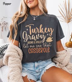 Celebrate Friendsgiving and Turkey Day in style with this Thanksgiving funny shirt that says "Turkey Gravy Beans & Rolls Let Me See That Casserole" on a comfy Comfort Colors fall shirt. Perfect for adding humor to your holiday gathering, this Friendsgiving shirt is a must-have for anyone who loves Thanksgiving tees with a playful twist. Whether you're rocking it at a family dinner or a Friendsgiving feast, this fall crewneck shirt brings comfort and laughs. Designed as the perfect thanksgiving s Thanksgiving Letter Print Crew Neck Top, Funny Adult Thanksgiving Shirts, Thanksgiving Crewneck, Thanksgiving Shirts For Women, Friendsgiving Shirt, Casual Autumn Outfits Women, Friendsgiving Feast, Casual Thanksgiving Graphic T-shirt, Thanksgiving Cotton T-shirt With Crew Neck