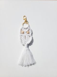 a white keychain with a tassel hanging from it