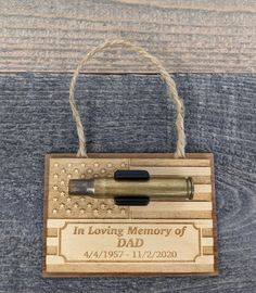 a wooden plaque with a pen on it that says, in loving memory of dad