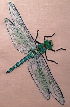 a green dragonfly sitting on top of a pink surface