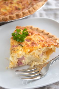 a slice of ham and cheese quiche on a plate with a fork