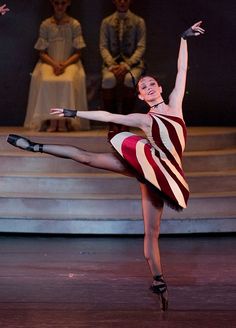 a woman in a striped dress is dancing on stage