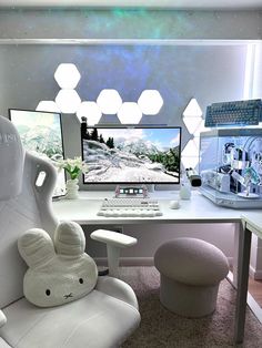 two computer monitors sitting next to each other on top of a white desk in front of a window