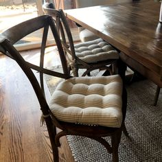 a wooden table with chairs and a bench in front of it on top of a hard wood floor