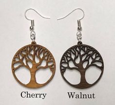 two wooden earrings with tree designs on them