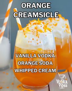 two glasses filled with orange creamsice and topped with whipped cream on the side