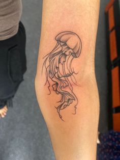 a black and white jellyfish tattoo on the arm