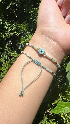 DAINTY OJO BRACELET ON AQUA STRING This bracelet is about between our MEDIUM About 6.5"-6.75 BUT   It has a sliding macrame knot for opening and closing, & to make it bigger if you have to. I make sure the macrame knot is tight and secure incase you need to make it bigger it won't slide, It will stay in place.  If you have any questions please Message us!  Thank you, RedHilos Adjustable Turquoise Bracelets With Evil Eye, Adjustable Spiritual Evil Eye Bracelet With Tiny Beads, Adjustable Green Evil Eye Bracelets, Adjustable Green Evil Eye Bracelet, Adjustable Turquoise Evil Eye Bracelet With Round Beads, Adjustable Turquoise Beaded Bracelets With Evil Eye, Green Beaded Bracelets With Evil Eye For Gift, Adjustable Turquoise Evil Eye Bracelet, Adjustable Beaded Green Evil Eye Bracelet