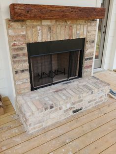 a fire place sitting on top of a wooden floor next to a door and window