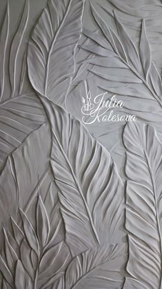 a white wall with some leaves on it and the words julia nelson written in white