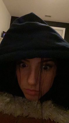 a woman wearing a hoodie looking at the camera with an angry look on her face