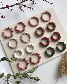 several pairs of small hair clips sitting on top of a sheet of paper next to flowers