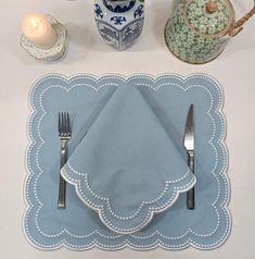 a place setting with silverware and blue napkins