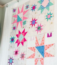 the wall is decorated with many different colored stars on it, including pink and blue