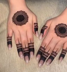 two hands with henna tattoos on them, one is black and the other is white