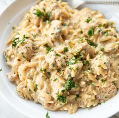 a white bowl filled with pasta and meat