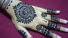 a woman's hand decorated with hennap and black beads on it,