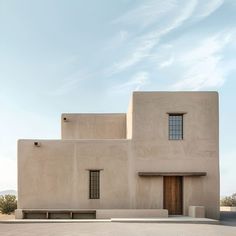 an adobe - style building with two doors and windows