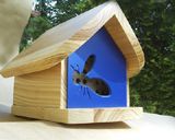 a blue birdhouse with an ant on it's side