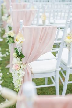 rows of white chairs with pink sashes and flowers