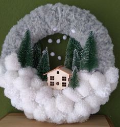 a house in the clouds with trees and snow around it on top of a table