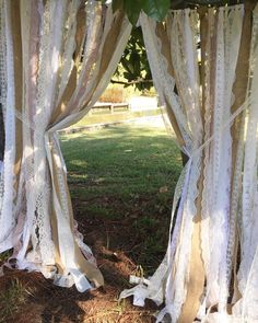 an outdoor area with white curtains and grass