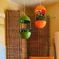 three hanging planters with plants in them on the wall next to a chair and table