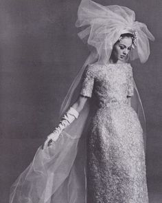 an old fashion photo of a woman in a wedding dress and veil with flowers on her head