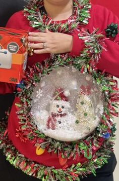 a woman holding a christmas wreath with a santa clause on it